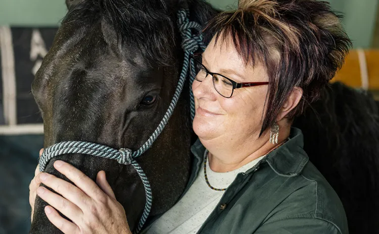 Woman petting a horse.